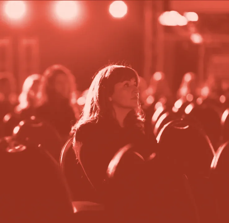 Nora Hasani listening in a conference audience