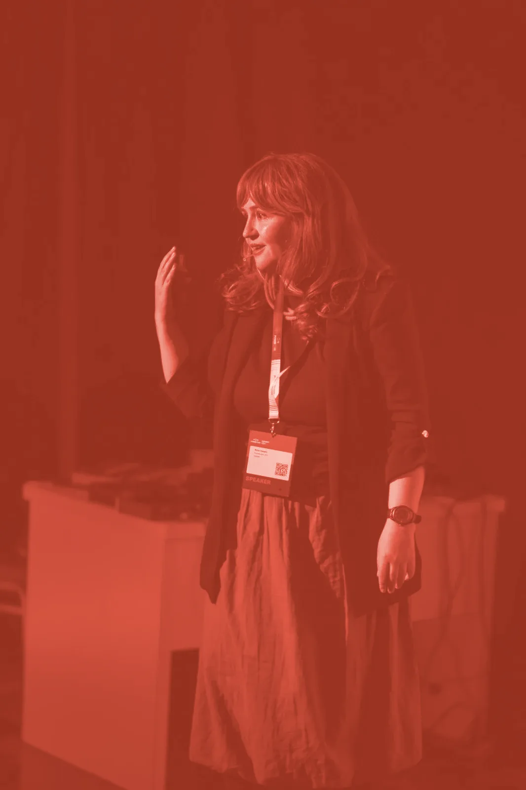 Nora Hasani speaking on stage at a conference